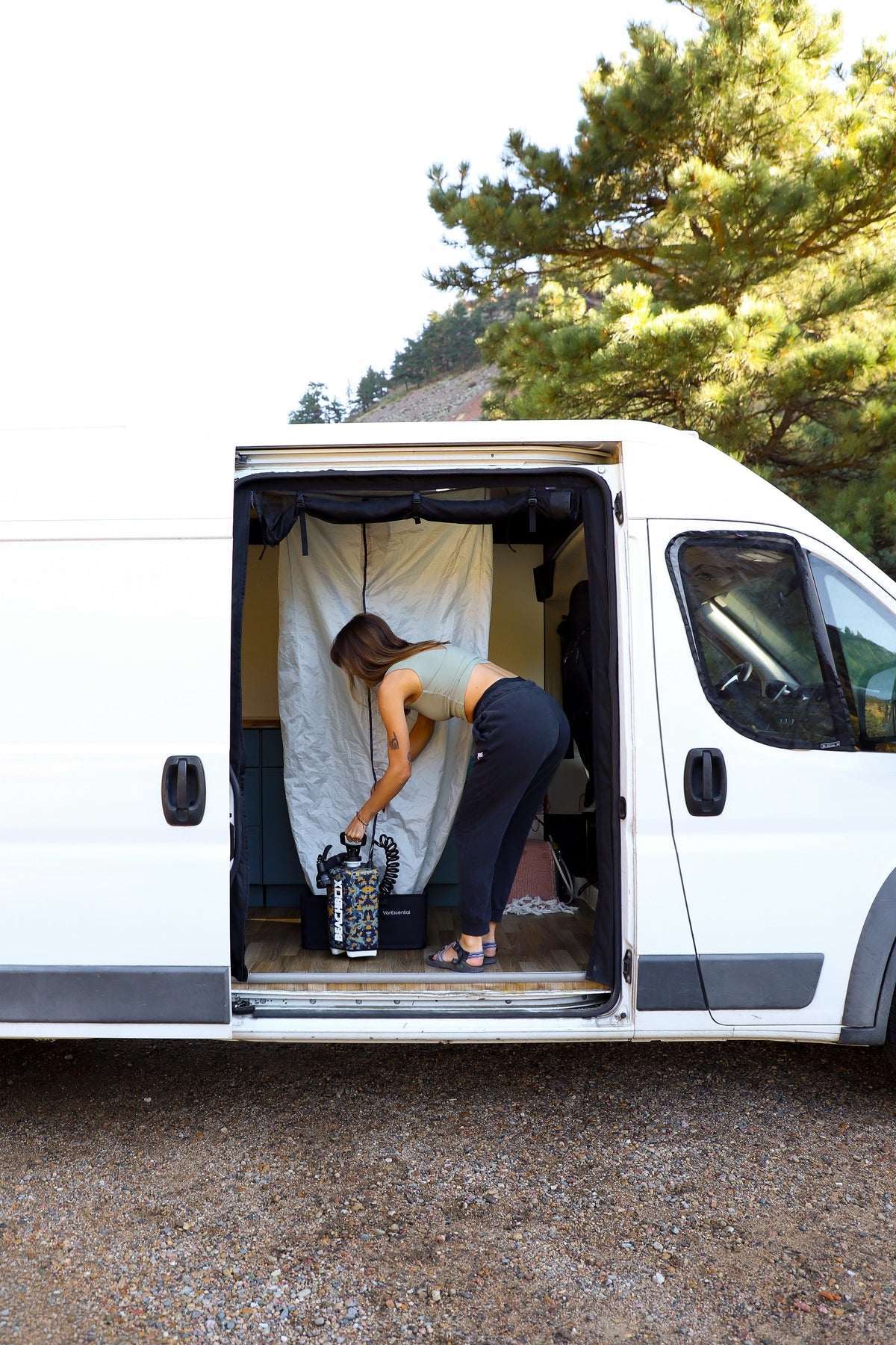 BeachBox portable shower tank set up beside a van build