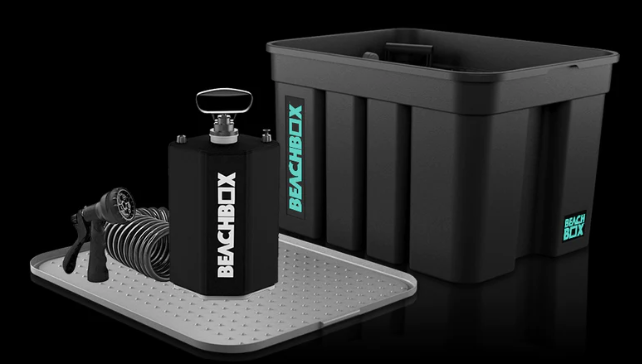BeachBox storage box with lid beside a shower tank, coiled hose and changing mat