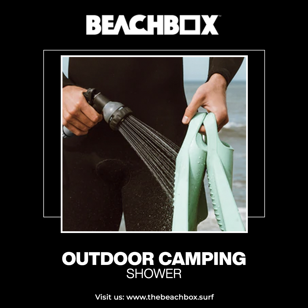 Surfer in a wetsuit rinsing swim fins with a BeachBox outdoor camping shower